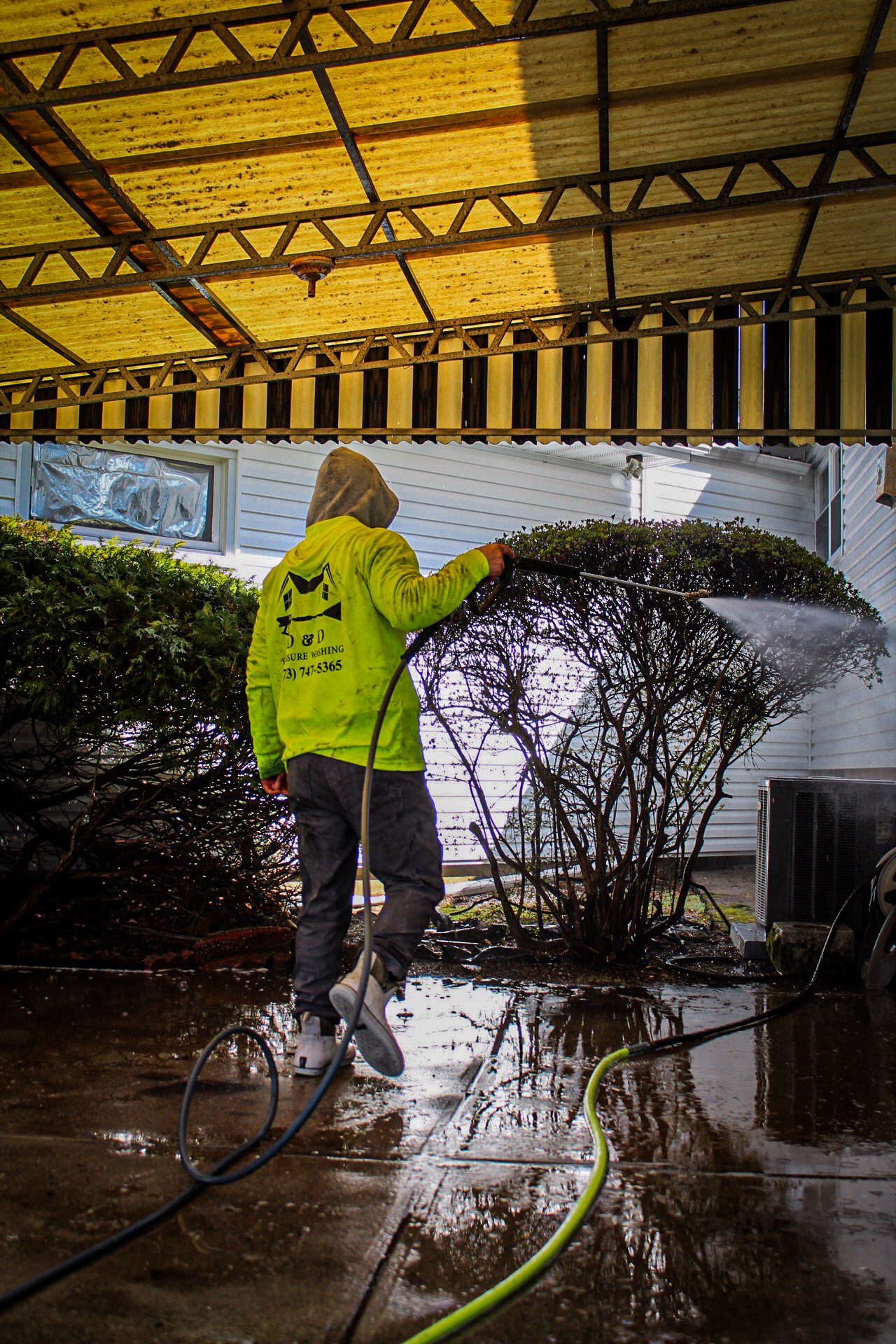 Darius cleaning a paver patio with a surface cleaner in North Jersey