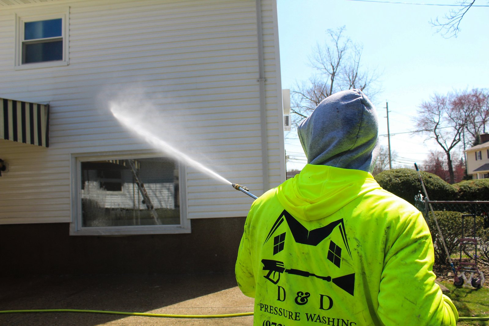 Darius soft washing the back of a house in North Jersey