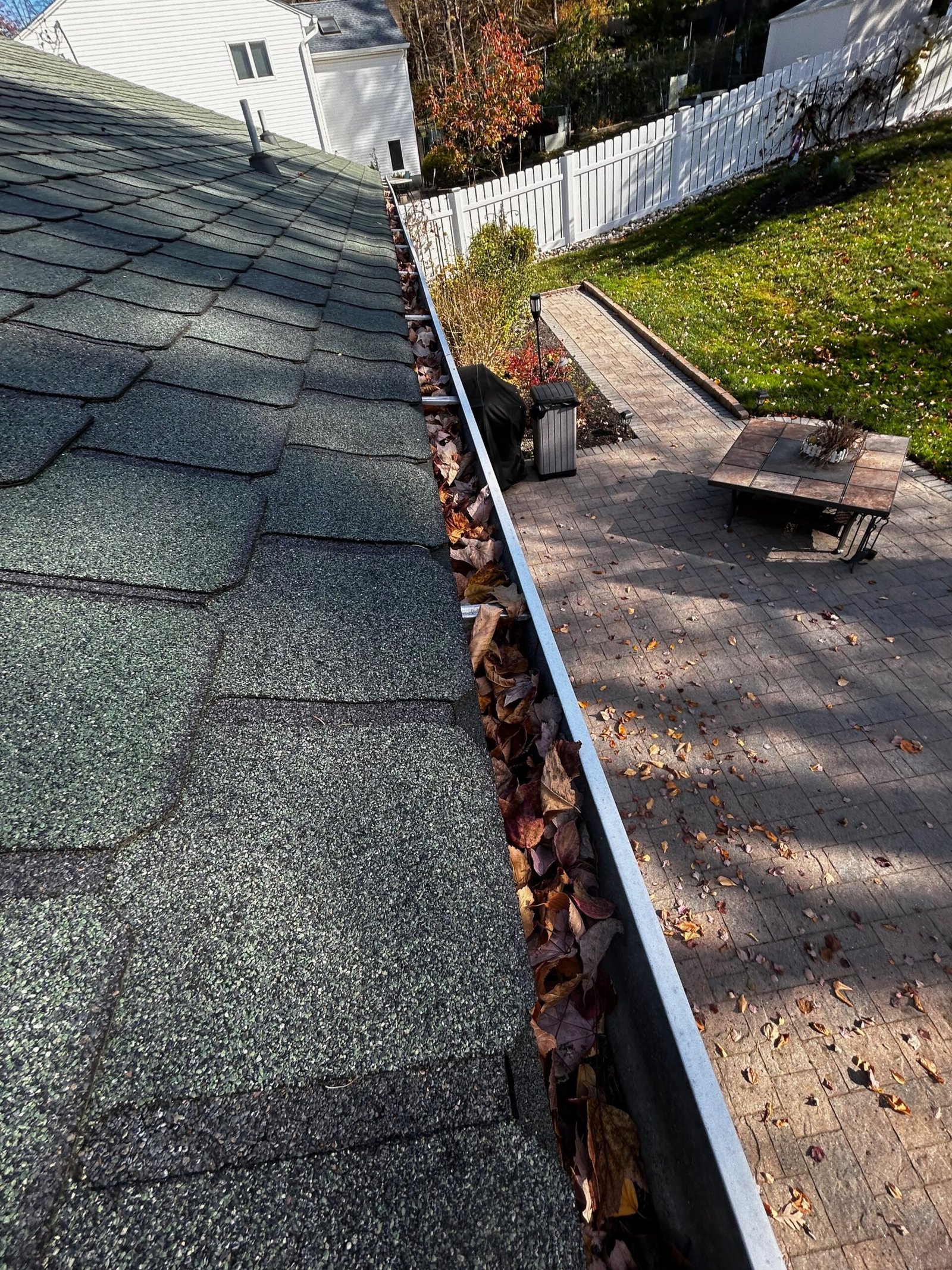 Fall leaves packed into a gutter on a North Jersey roofline before D&D cleared it